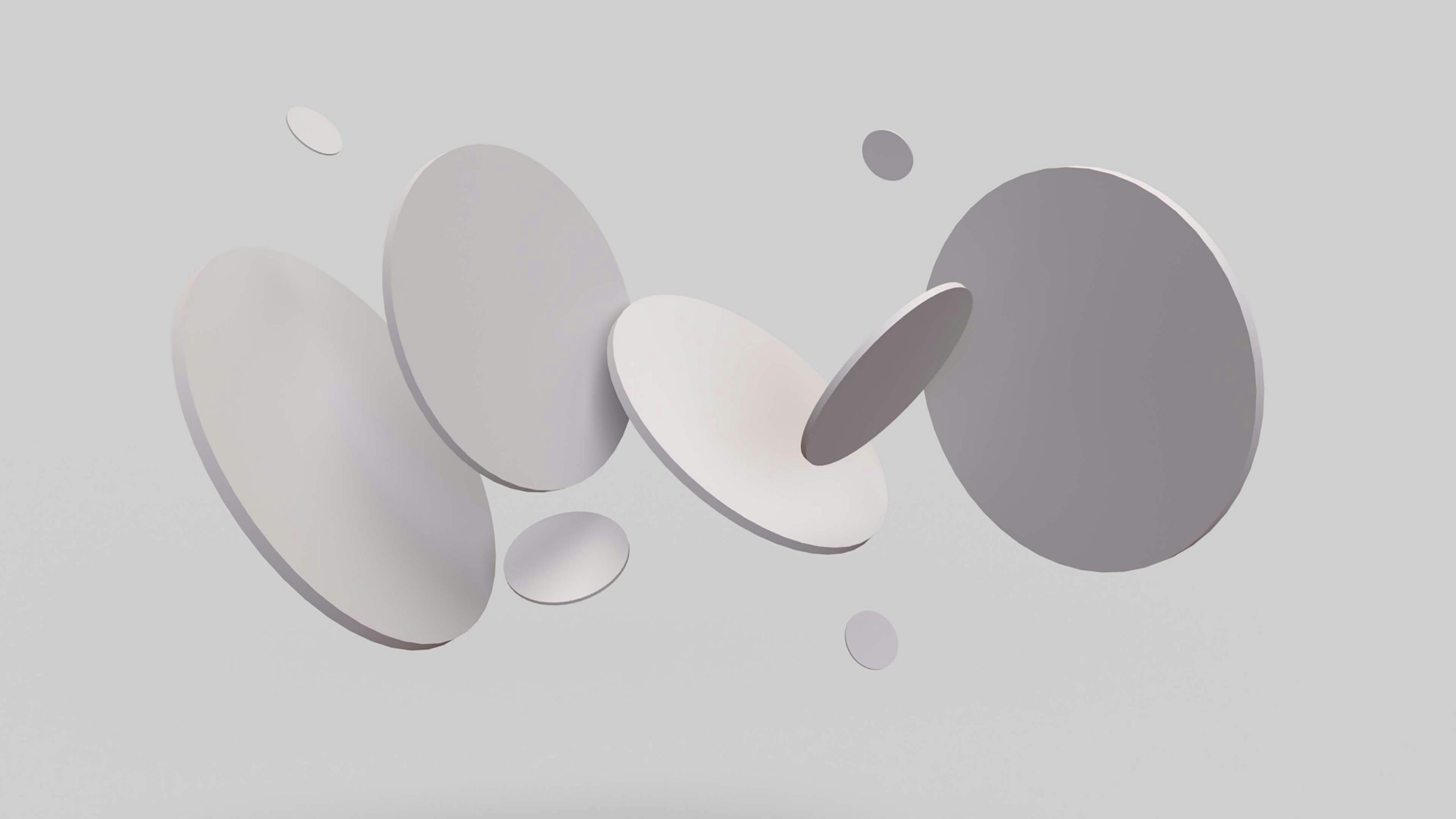grey floating discs of different sizes and shades on a light grey background